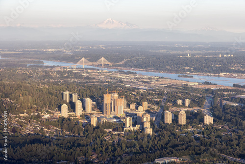 Aerial View from Airplane of Residential Homes and Buildings in a modern city during sunny summer sunset. Taken in Laugheed, Burnaby, British Columbia, Canada. photo