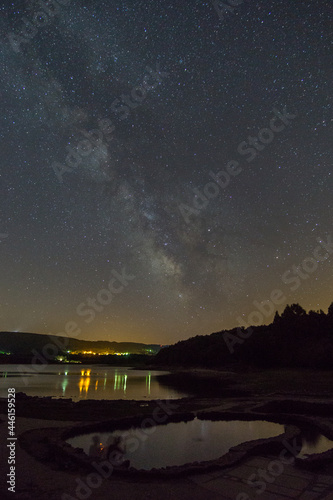 milky way over reservoir lake with old roman thermal springs Os banos de Bande, Spain