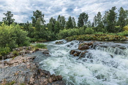 Summer landscape with a waterfall. Western Siberia
