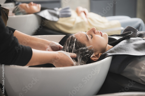 hairdresser washing client's hair at salon. happy young women customer relax and comfortable while washing hair, luxury hair spa by professional hairstylist