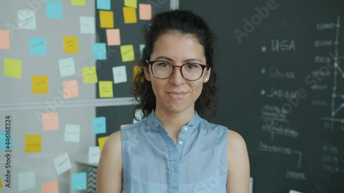 Portrait of happy young mixed race woman smiling stanidng in creative workplace alone and looking at camera. Youth and modern business concept. photo