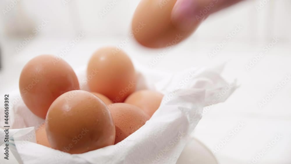 Close up male hand putting brown eggs to the carton. Close up male hand putting brown eggs to the carton.