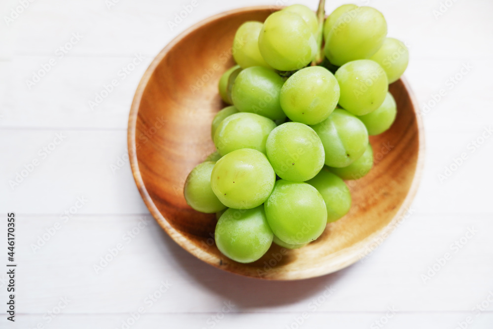 green grape on wooden dish and table background. Fresh organic concept. Shine Muscat, grape, fresh green, natural, natural food, Healthy. green grape on wooden dish and table background. Fresh organic concept. Shine Muscat, grape, fresh green, natural, natural food, Healthy.