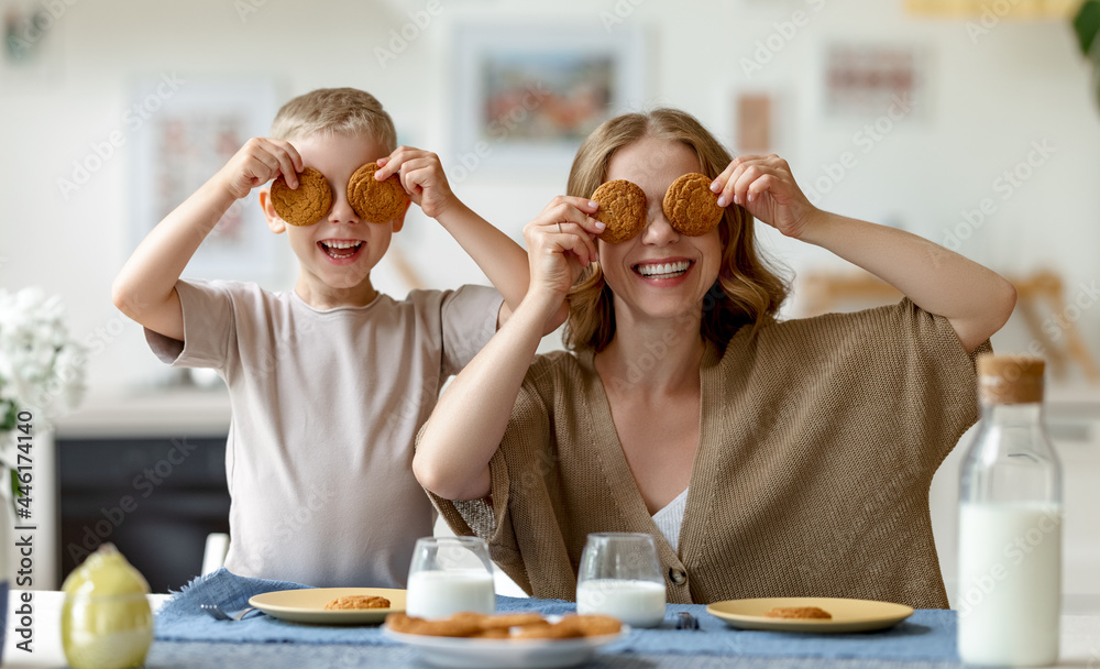 Mother and son playing with cookies during breakfast