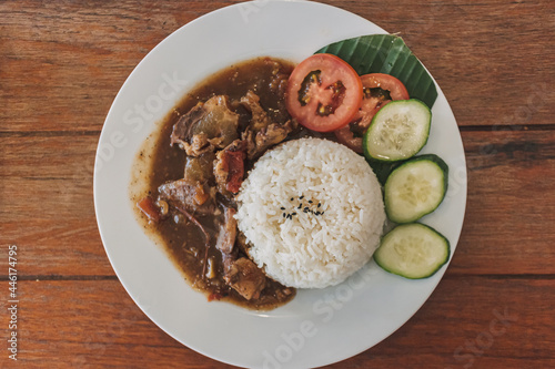 Thai stewed beef with rice served on white dish in the cafe.