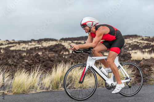 Cycling sport triathlete man biking on triathlon bike. Fit male cyclist on professional triathlon bicycle wearing aero helmet and trisuit for race in Kailua Kona, Big Island, Hawaii, USA. photo