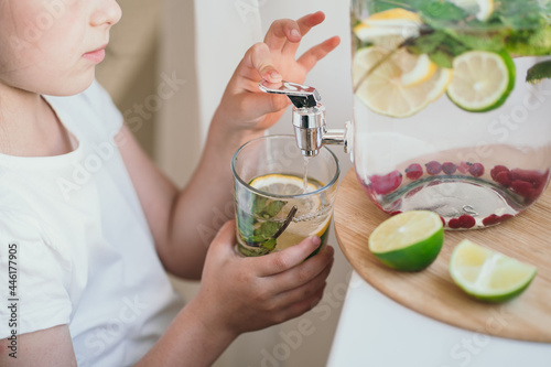 Tableau sur toile The child himself pours lemonade into a glass