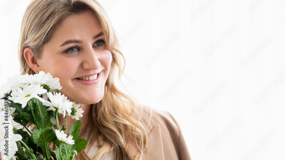 Happy woman day. Spring holiday. Body positive. Portrait of smiling beautiful obese overweight woman face with white flowers bouquet isolated on light empty space background. Happy woman day. Spring holiday. Body positive. Portrait of smiling beautiful obese overweight woman face with white flowers bouquet isolated on light empty space background.
