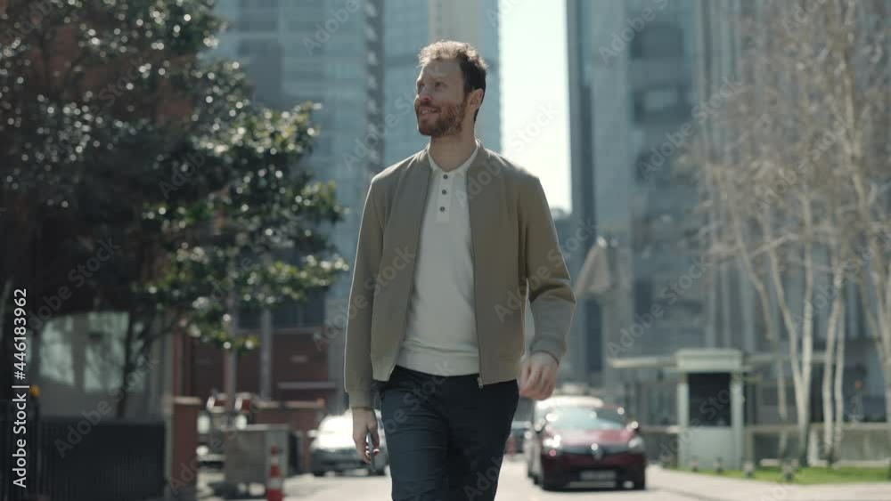 Smiling man walking on street and looking around Smiling man walking on street and looking around