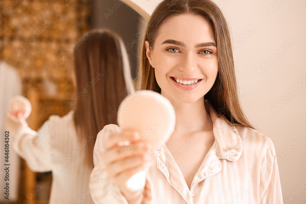 Beautiful young woman applying makeup in bathroom Beautiful young woman applying makeup in bathroom