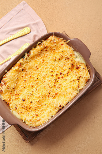 Baking dish with tasty green lasagna on color background
