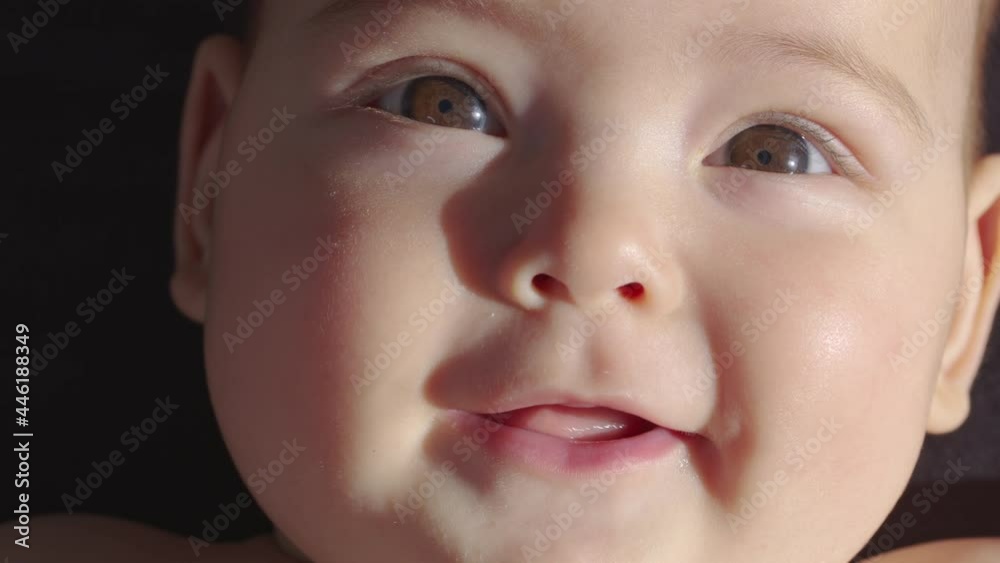 The look of the baby in the camera close up shot. A cute little baby is looking into the camera. Concept of caring for children, parental love. The look of the baby in the camera close up shot. A cute little baby is looking into the camera. Concept of caring for children, parental love.