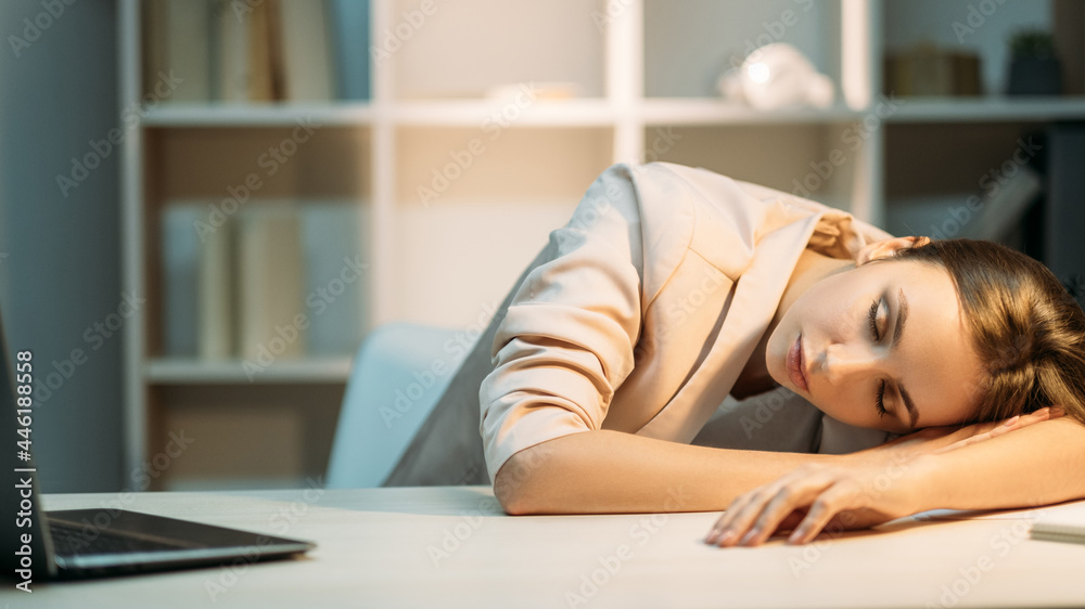 Night study. Working fatigue. Peaceful exhausted tired female student in sleeping with open laptop lying on desk at workplace. Night study. Working fatigue. Peaceful exhausted tired female student in sleeping with open laptop lying on desk at workplace.