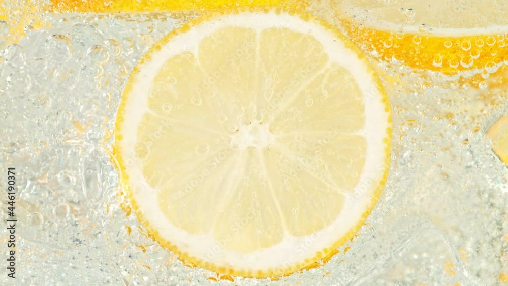 Super Slow Motion Shot of Fizzing Water with Lemon Slices and Ice Cubes in Glass at 1000 fps. Super Slow Motion Shot of Fizzing Water with Lemon Slices and Ice Cubes in Glass at 1000 fps.