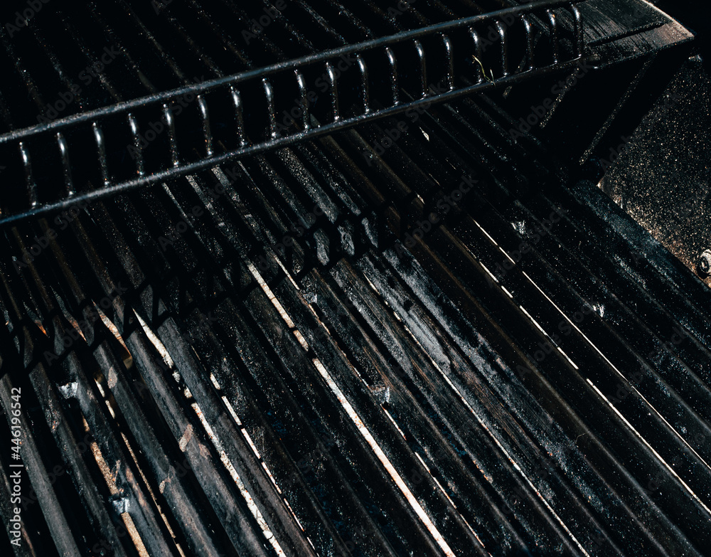Empty BBQ charcoal black grill or barbeque with black iron grate for cooking outdoor meal. Empty BBQ charcoal black grill or barbeque with black iron grate for cooking outdoor meal.