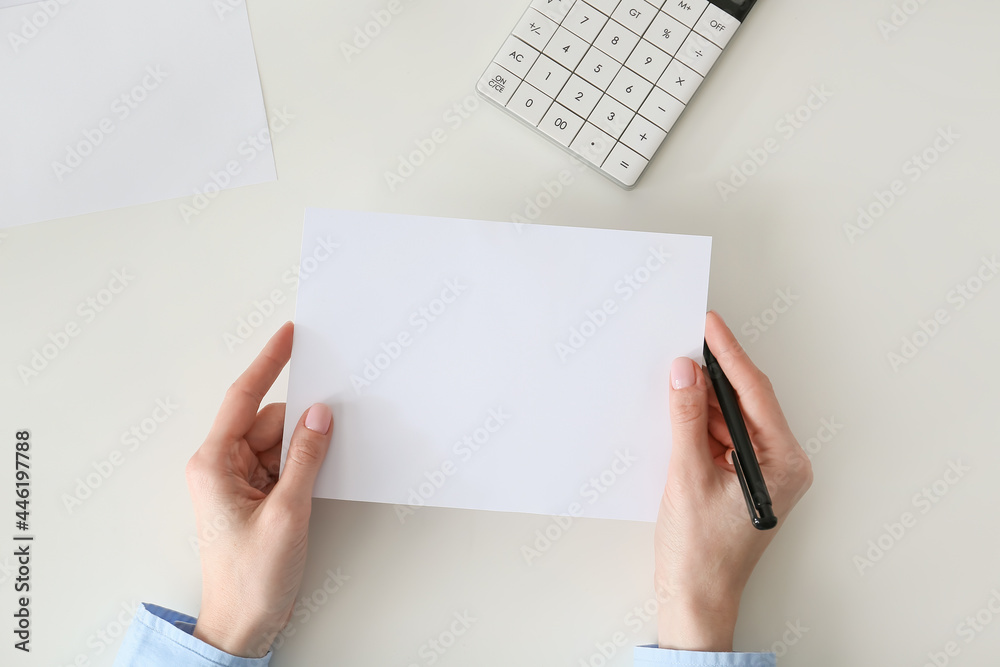 Female hands with blank sheet of paper on light background Female hands with blank sheet of paper on light background