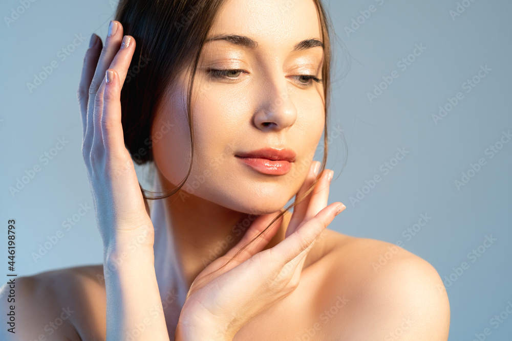 Facial skin care. Elegant woman. Spa beauty. Salon procedure. Peaceful gorgeous female with nude makeup touching smooth clean face isolated on blue. Facial skin care. Elegant woman. Spa beauty. Salon procedure. Peaceful gorgeous female with nude makeup touching smooth clean face isolated on blue.