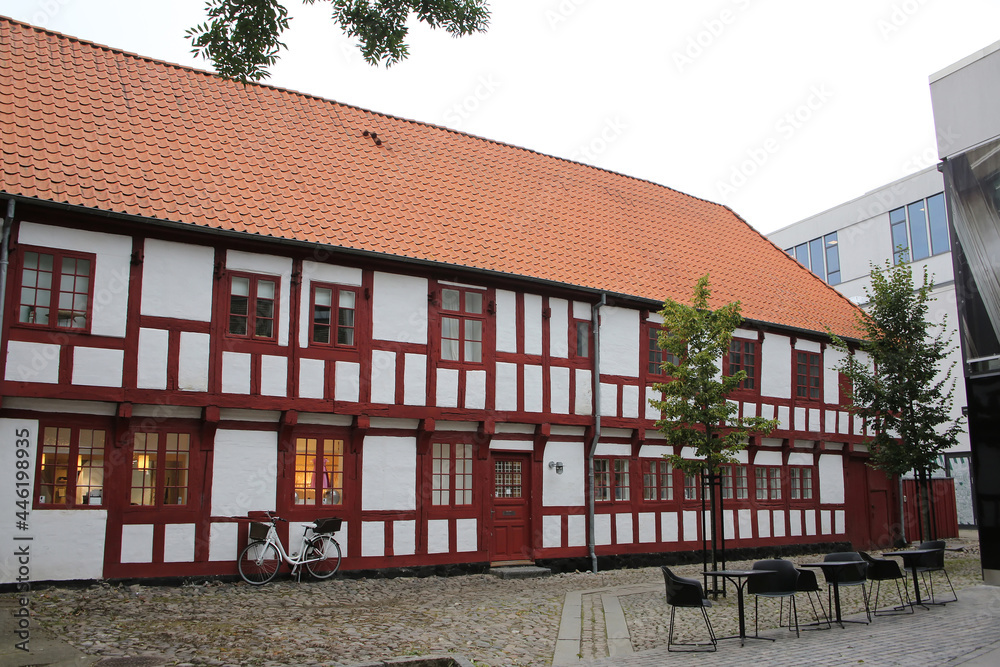 Historic white and red painted timbered building in the city center, Aalborg, Denmark.