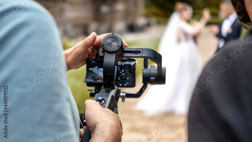Obraz na płótnie A cameraman recording a wedding ceremony using camera on a tripod w salonie
