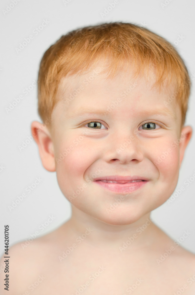 Portrait of a beautiful red-haired child close-up. 4 year old boy looking at the camera and smiling Portrait of a beautiful red-haired child close-up. 4 year old boy looking at the camera and smiling