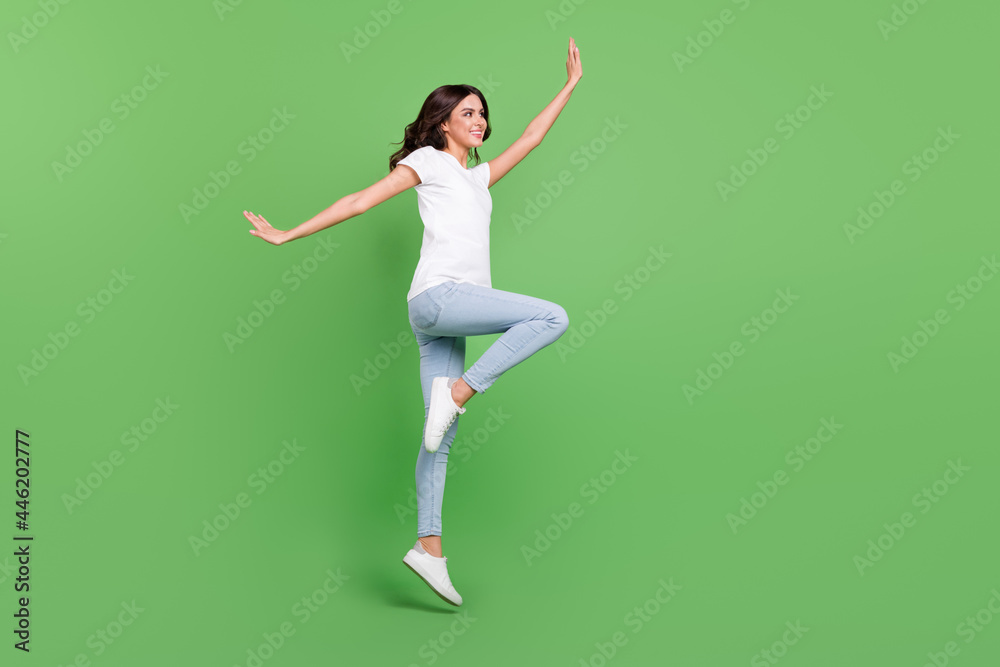 Full length profile photo of nice brunette millennial lady jump wear t-shirt jeans isolated on green color background