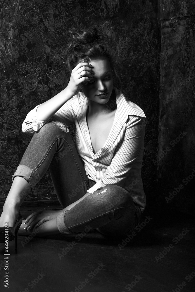 Studio portrait of a concerned woman sitting on the floor Studio portrait of a concerned woman sitting on the floor