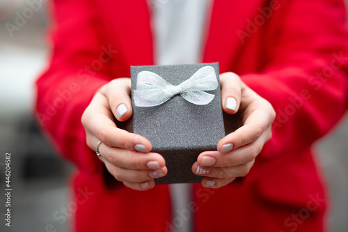 Woman in red coat holding a gift box