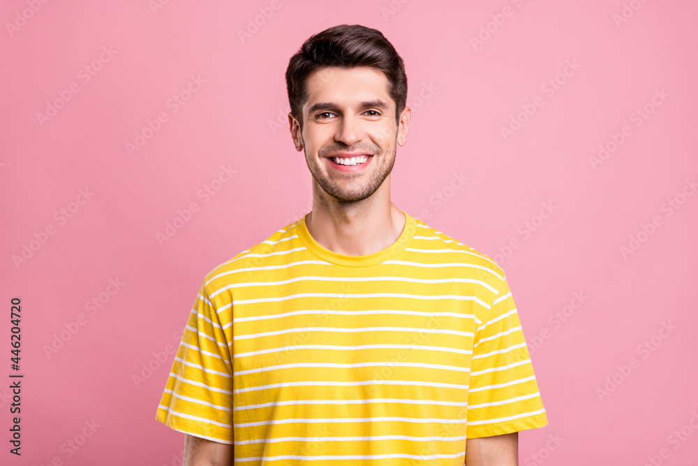 Portrait of attractive cheerful brunette guy wearing striped tshirt summer mood isolated over pink pastel color background Portrait of attractive cheerful brunette guy wearing striped tshirt summer mood isolated over pink pastel color background
