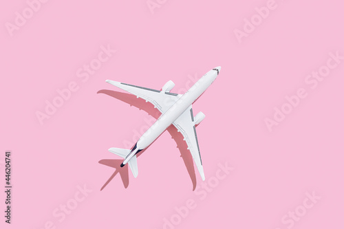 Passenger plane on a pink background. Travel and flights concept.