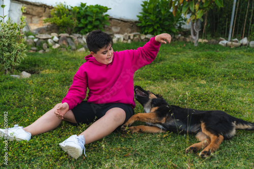 Niño jugando con un perro de raza pastor alemán en el jardín