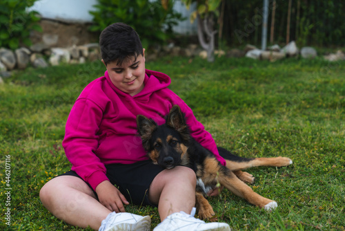 Niño jugando con un perro de raza pastor alemán en el jardín