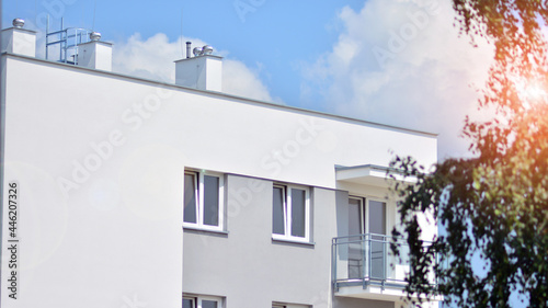 Fototapeta Naklejka Na Ścianę i Meble -   Modern apartment buildings on a sunny day with a blue sky. Facade of a modern apartment building. Glass surface with sunlight.