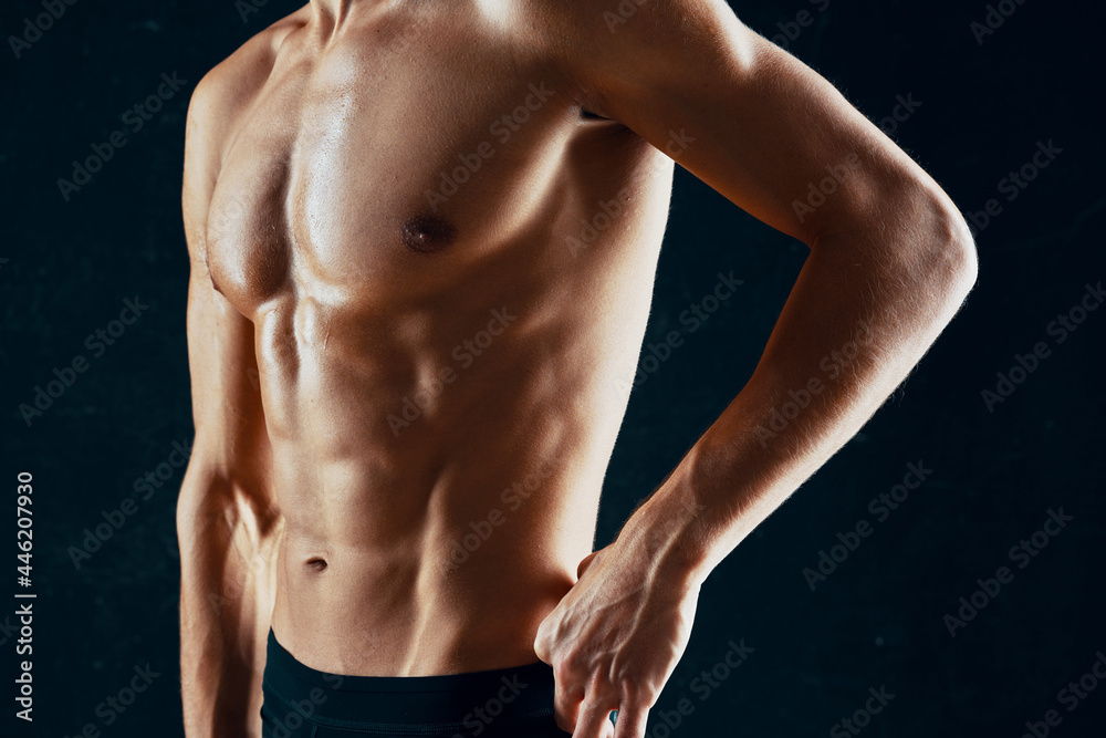 sporty man with a pumped-up muscular body in a towel dark background