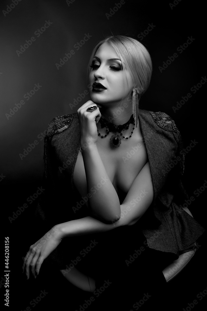 Fototapeta premium Stylish studio shot of a beautiful lady wears jacket on a naked body