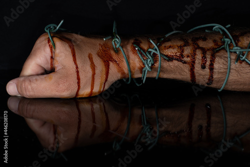 bloody hand with barbed wire symbolizing oppression during lockdown
