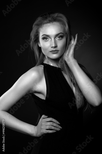 Stunning lady with long straight hair wears classic black dress