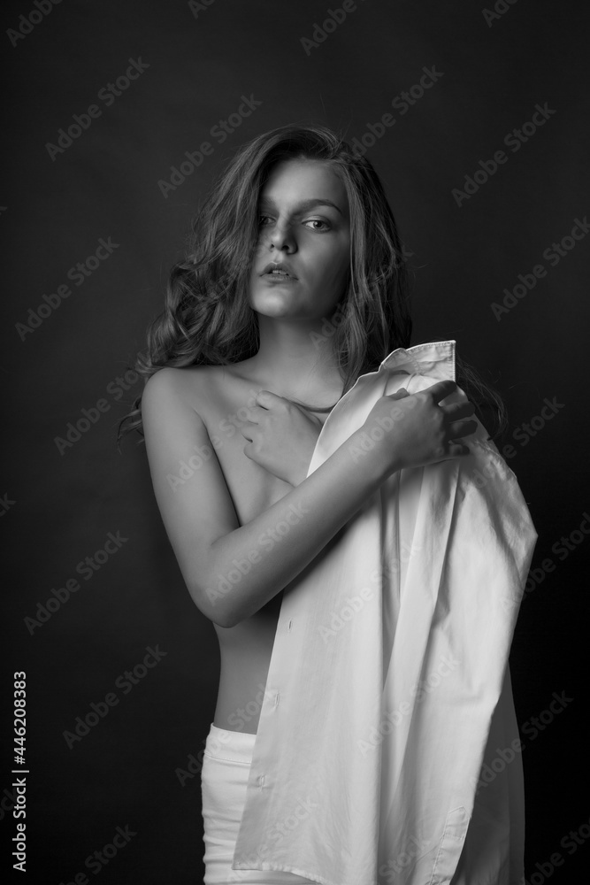 Seductive blond lady posing with bare shoulders at studio