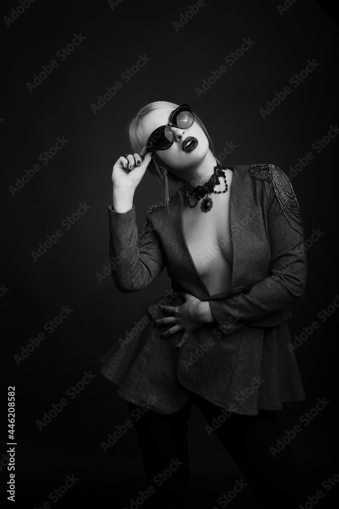 Monochrome studio portrait of a attractive blond woman wears sunglasses and jacket Monochrome studio portrait of a attractive blond woman wears sunglasses and jacket