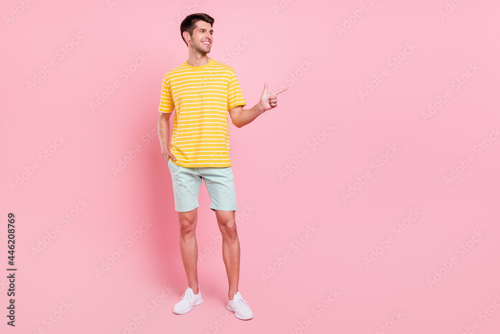 Full length body size view of attractive cheerful guy showing copy empty space ad isolated over pink pastel color background Full length body size view of attractive cheerful guy showing copy empty space ad isolated over pink pastel color background