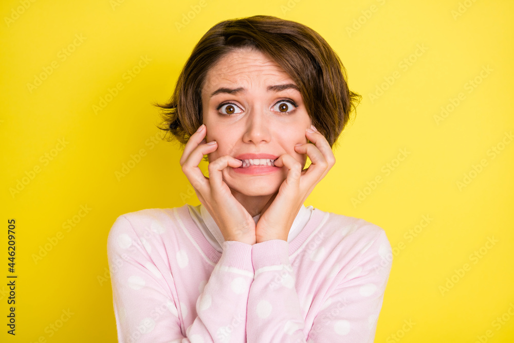 Photo portrait troubled afraid girl nervous biting fingers staring isolated bright yellow color background Photo portrait troubled afraid girl nervous biting fingers staring isolated bright yellow color background