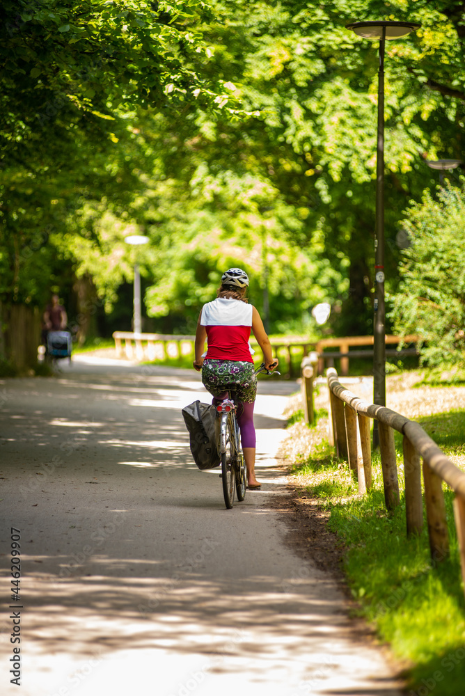 Fototapeta premium Woman riding a bicyle in summer in a bike path