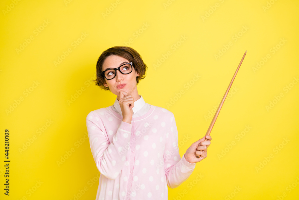 Photo of minded dreamy young woman point stick empty space tutor tracher isolated on vivd yellow color background Photo of minded dreamy young woman point stick empty space tutor tracher isolated on vivd yellow color background