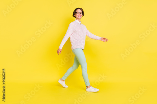 Full length body size photo of cheerful model going forward in casual clothes isolated vivid yellow color background