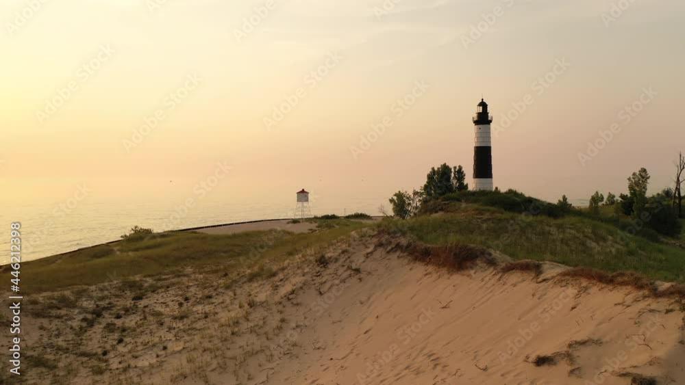 Big Sable Point Lighthouse on the shore of Lake Michigan in Ludington State Park, Michigan, USA. Flying low over sand dunes at sunset.