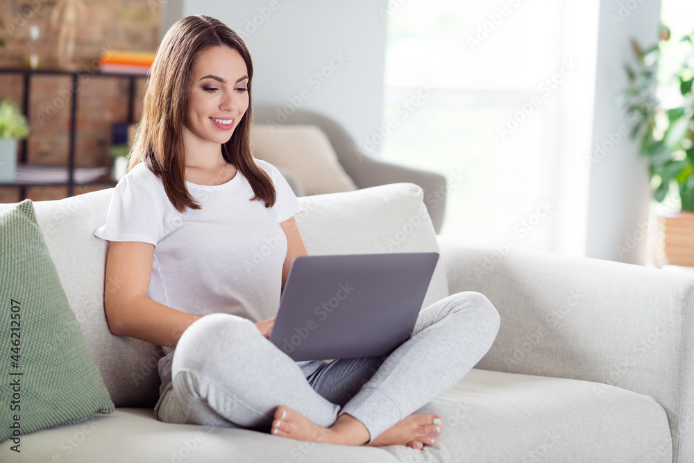 Photo portrait brunette woman sitting on couch at home working on laptop wremotely while quarantine Photo portrait brunette woman sitting on couch at home working on laptop wremotely while quarantine