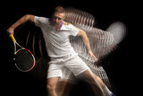 Power and speed. Young man, professional tennis player in motion and action isolated on dark background with stroboscope effect.