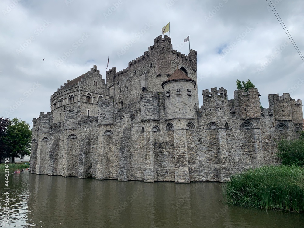 Facade of the Gravensteen medieval ages castle surrounded by water canal. Ghent, East Flanders, Belgium.