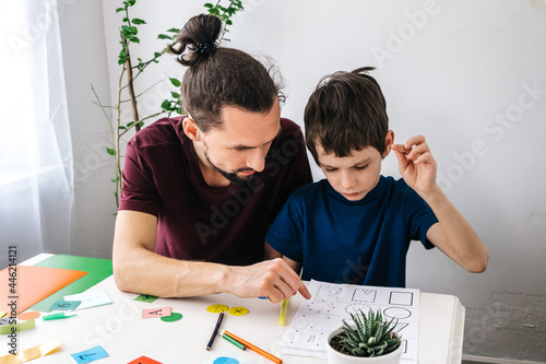 Man teacher teaches autism boy during therapy. Autism, asperger child lifestyle concept photo