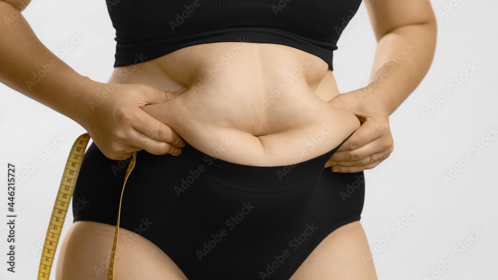 Stockfoto med beskrivningen Woman body fat belly. Obese woman hands holding  excessive tummy fat. Change diet lifestyle concept to shape up healthy  stomach muscle. Studio anonymous shot photo of body parts.