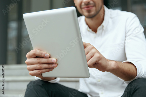 Businessman sit on stairs and using digital tablet